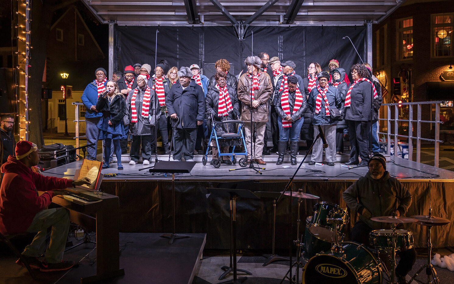 Carols by Candlelight singers on stage.