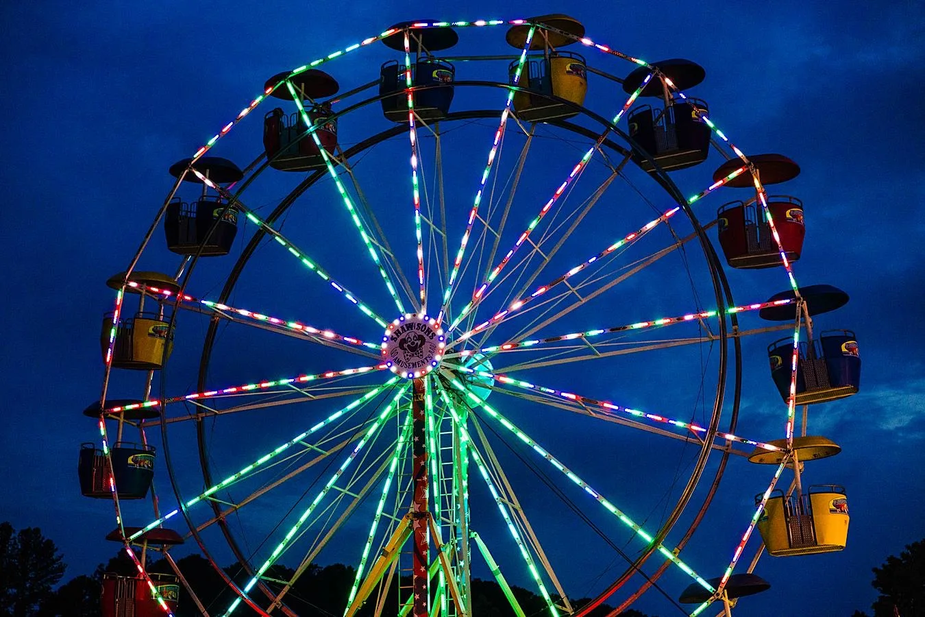 Ferris wheel with bright lights and an evening sky.