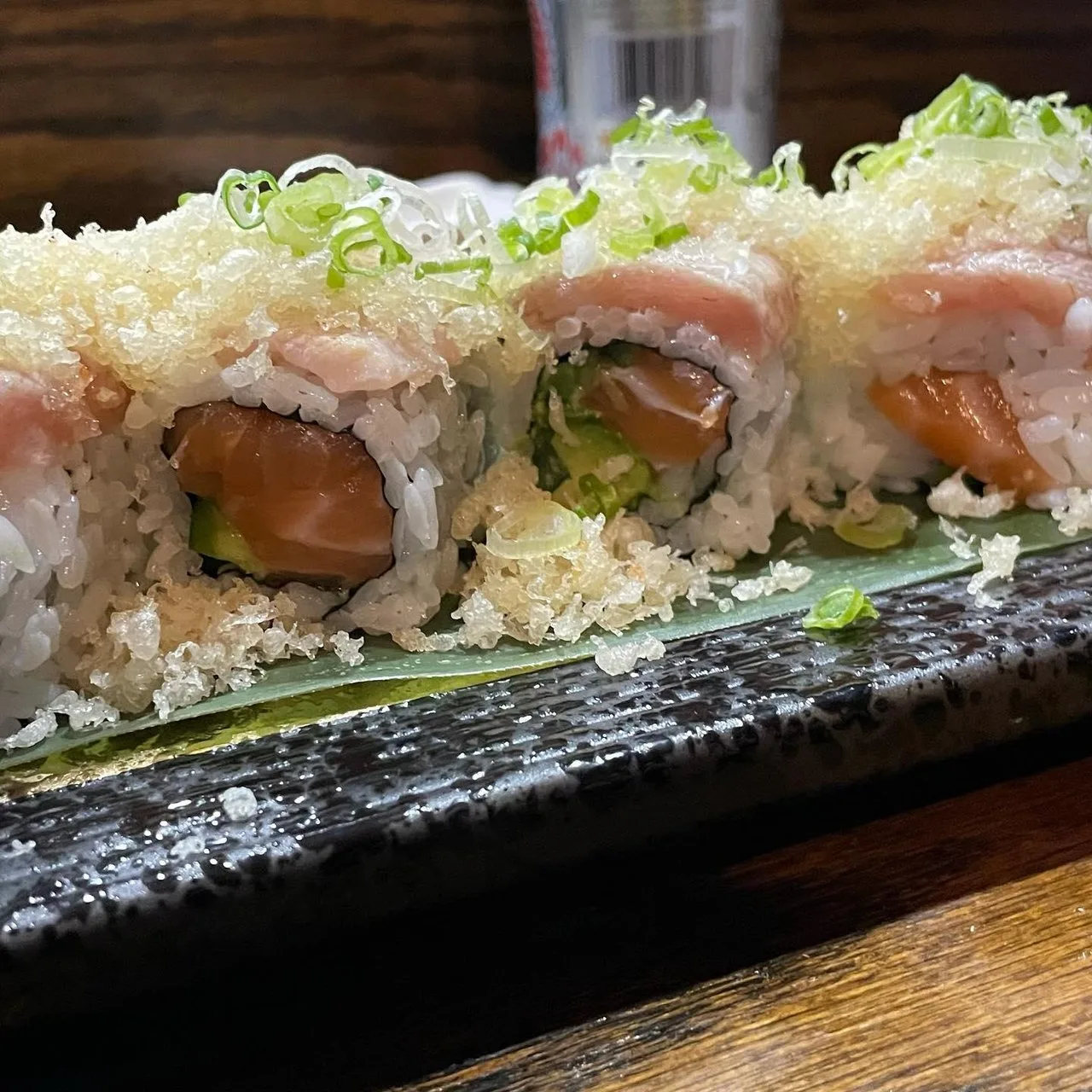 Sushi roll laid out on black serving plate a top of seaweed from U Sushi.