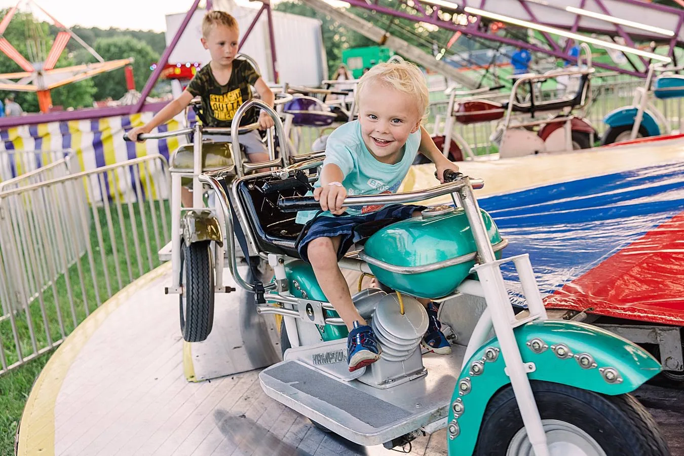 Toddler on motorcycle themed carnival ride.
