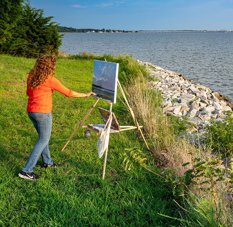 Plein Air Easton painting competition artist in Talbot County, Maryland. Woman painting by the water.
